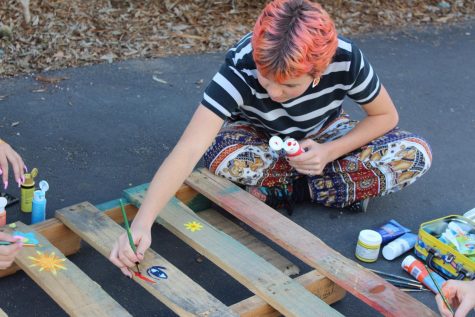 Lilian Landre paints the wooden pallets that hold the succulents