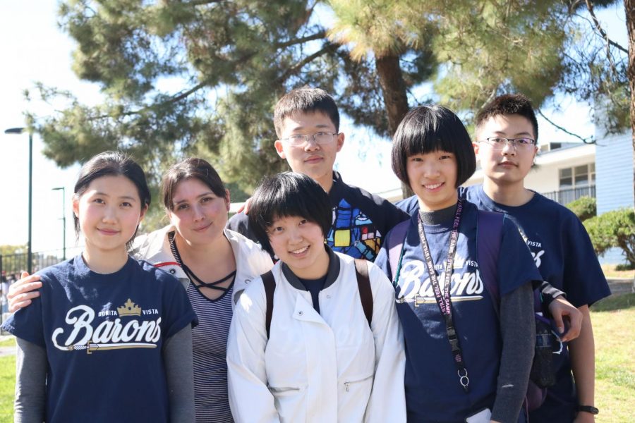 Five of the chinese exchange students pose alongside Program Coordinator Carla Ruiz-Velasco. This was one of the last
things they did before driving away on one of the Sweetwater Union High School District school buses from their final
day on the Bonita Vista High campus.