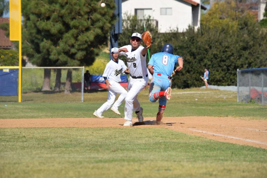 Senior and first baseman Isaac Almendarez (8) reaching out to catch the baseball with his right foot still touching the base. Senior and second baseman Caiden Regadio (9) runs behind him to back up Alamendarez.