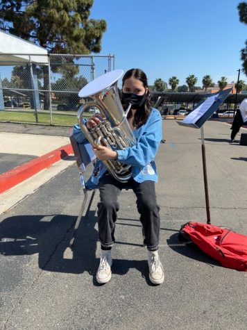 Club Blue member Alexis Garcia playing the euphonium through the specialized mask. Club Blue practices just outside the band room.