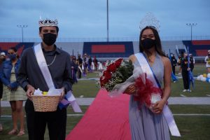 Bonita Vista High (BVH) 2021 Homecoming King, Frankie Javier and Homecoming Queen, Madison Bianes pose for the camera in front of the Color Guard. Standing at the end of the red carpet, Javier and Bianes were announced as the King and Queen at a football game.