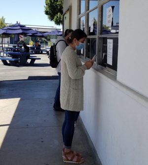 Senior Alexa Lazarit buys her Prom ticket from the ASB after school. Just as Lazarit must wear a mask while purchasing a ticket, she will also have to wear a mask at the event to follow the restrictions put in place given the current circumstances of the COVID-19 pandemic.