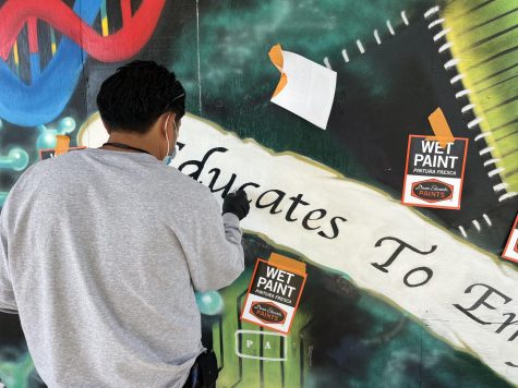 Sweetwater Union High School District (SUHSD) dispatch worker paints over the graffiti in attempt to restore the mural to its original state. SUHSD was called early in the morning on Nov. 1 to fix the damage done to BVH.