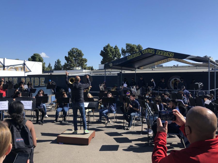 Assistant Principal Dr. Jason Josafat stands on the conductor platform during the Club Blue performance. He conducted one of many songs Club Blue performed during lunch.