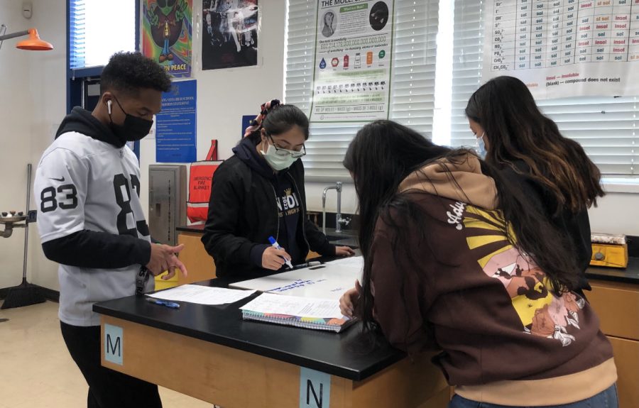 From left to right Advanced Placement (AP)/International Baccalaureate (IB) Chemistry students junior Isaiah Chappell, senior Denise Wu, senior Tannya Meza, and junior Sofia Barbabosa work to figure out the reactivity of certain metals. They, as a team, review their most recent lab results and connect them to their new unit of Electrochemistry.