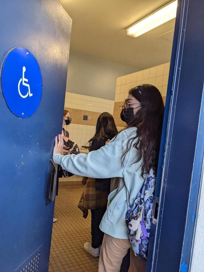 Bonita Vista High junior Jaynne Quezada holds open the 500s bathroom door during passing period. The 500s is the only open bathroom during the passing period between fifth and sixth period so the wait times are longer.