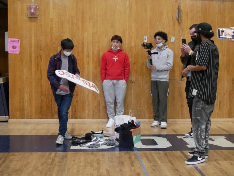 (Left to right) Junior Sean Advincula wins a skateboard, while junior Dante Herrero and the owners of Arts-Rec Mike Metcalf and Kellen James spectate. The skateboard club held a raffle to give out gifts to their members.