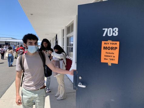Senior Marcello Garbo opens the door of room 703 where a Morp flyer is posted. Two days before Morp, the 2022 Task Force posted these flyers as a final effort encouraging students to purchase tickets before the dance.