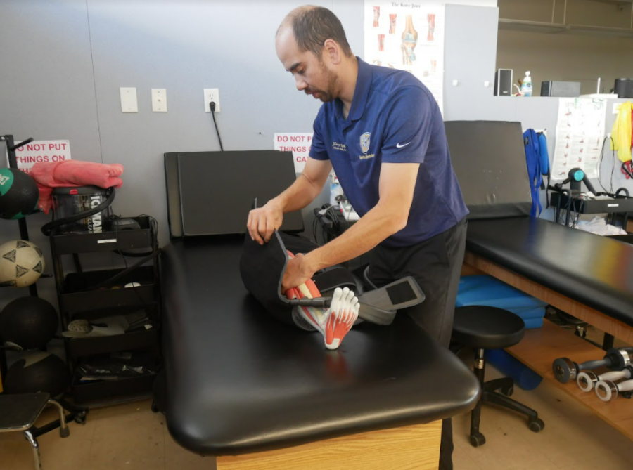 BVH Athletic Trainer George Lafiguera demonstrates how to use one of multi-
ple sleeves for the Game Ready machine on a fake leg used for teaching. The

sleeve is ony one piece of lots of equipment the Sports Medicine program got this year.