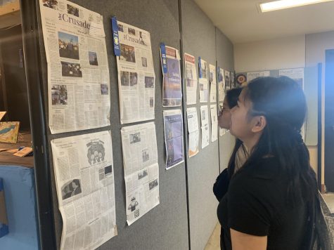  Former co-Editor-in-Chief Laurinne Eugenio (front) and former Managing Editor Yealin Lee (back) looks at the newspapers and the first place ribbon the Crusader received. Despite coming back from distance learning, the Crusader faced challenges for the publication to have high quality content.