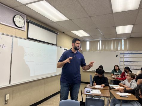 Nour Nona explains an Integrated Math II concept to his attentive students. He answers a question that a student asked during independent work.