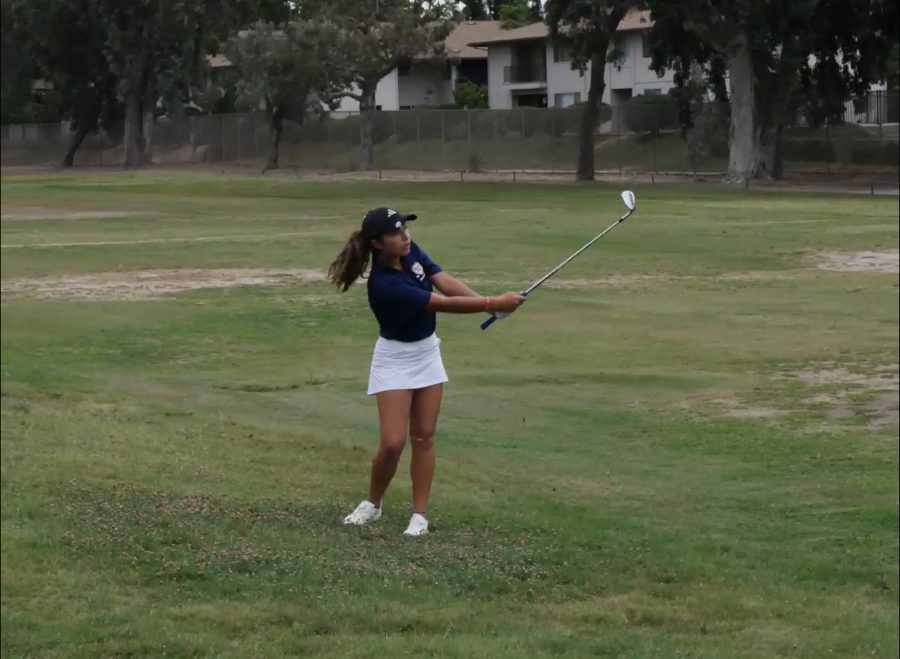 Freshman Leilani Mena swings and aims to the put while going against Academy of Our Lady of Peace. Leilani is part of the first pair of golfers in the match.