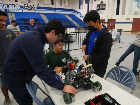 Minutes before a match Team A from Bonita Vista High repair their robot at Olympian High School in Chula Vista. On the far left, Sebastian Higuera oversees on his left Noah Caballero, Gabriel Jimenez worries for time deadlines shortening as Alvin Lim (right) works on the robot. 