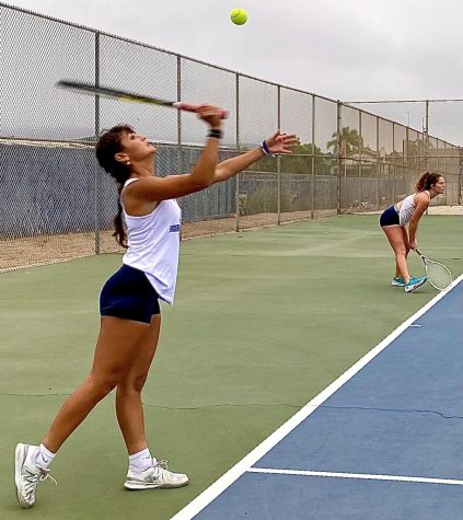 On Oct. 13 at Bonita Vista High, the girls tennis team plays against Mater Dei High. Ready to serve doubles, junior Paulina Escaiadillo begins the match serving while her doubles partner and junior Catherine Wunderly readies her stance.