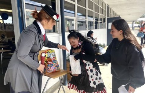On Oct. 31 at Bonita Vista High, Baron Buddies go around school trick or treating. Psychology teacher Laura Lowery dressed as Mary Poppins and hands out candy to a pair of Baron Buddies. 