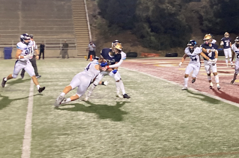After catching the pass, sophomore and wide receiver Marcos Pena drags Olympian High School’s (OHS) linebacker and a defensive with him to bring the ball within inches of the goal line. 
