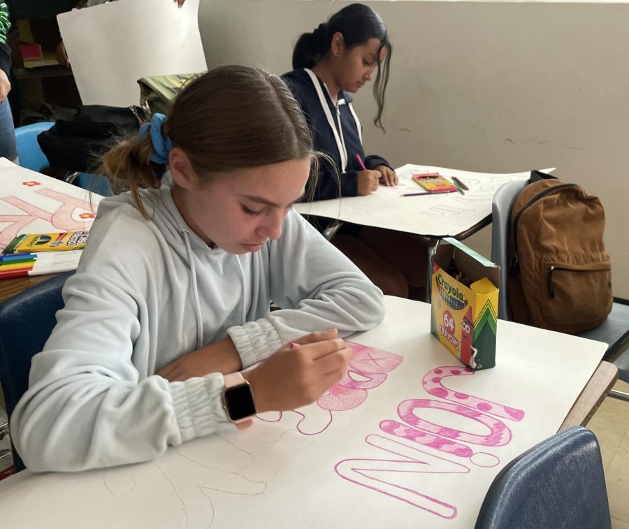 Freshman Ella Roberts and Melissa Martinez Murillo (left to right) make posters for future fundraising events during a Pretty in Pink meeting. Meetings take place every Tuesday in room 206.