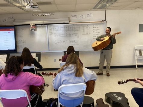 Guadalupe Gonzalez begins the class warmup as he plays the Guitarron (a large bass guitar). Each student is incorporating their own part into the symphony that is being created. 