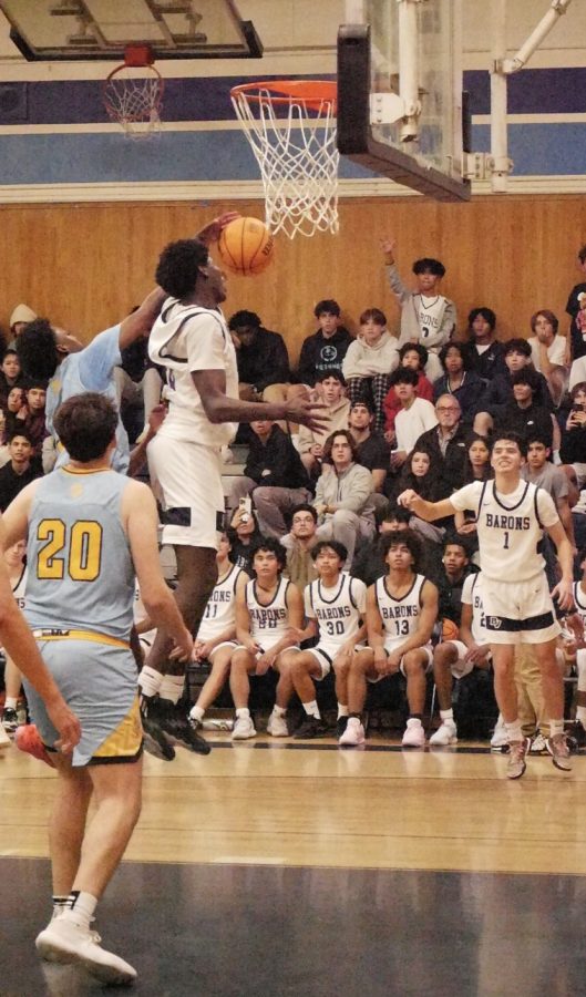 Bonita Vista Highs (BVH) boys varsity basketball power forward and sophomore Aaron Owens (22) leaps to shoot a basket against San Ysidro High’s (SYH) basketball team. The game ended with a score of 83-64, BVH defeated.
