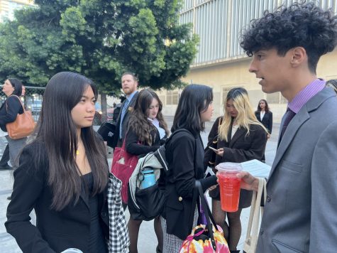 On Feb. 9, the Bonita Vista High Mock Trial team competed in their first round of competition for the 2022-2023 school year. Junior and defense attorney Eliza Noblejas (left) and junior and defense witness Alexander Roman (right) practice their direct examination lines in front of the San Diego Central Courthouse, as the defense team waits for all the team members to arrive.
