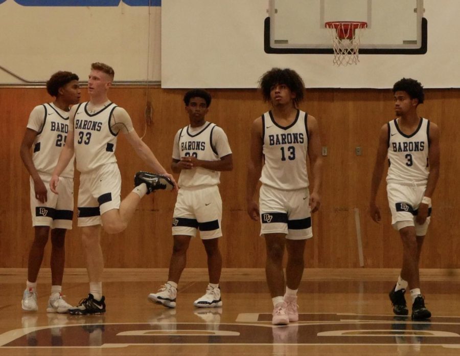 From left to right junior Torrean Smalley (25), power forward, small forward and senior Michael Hansen (33), Jordan, shooting guard, small forward and senior Gavin Hormaechea (13) and point guard, shooting guard and sophomore Treyvon Davis (3) stretch and warm up in preparation for the game. They progressively get ready for tipoff.