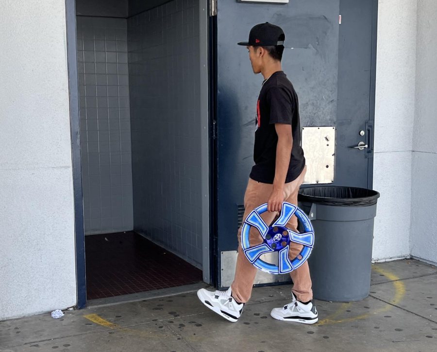At Bonita Vista High (BVH) on April 19,  junior Fransico Quinones walks to the restroom carrying a painted Toyota hubcap that Auto Shop teacher Jose Leyva uses as a hall pass. This is just one of many interesting hall passes used at BVH.