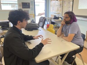 On April 19 at Bonita Vista High, International Baccalaureate coordinator Jared Phelps is talking to senior Cyan Schiele during lunch. Seniors who have a 4.2 GPA are eligible for a white gown.