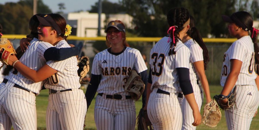 On May 9, senior Sofia Barbabosa (10) embraces junior Irie Iapala as their game nears a close. After a strong inning for the Lady Barons giving them an 8 point lead, the team huddles in anticipation for the out that leads them to winning their senior night game.