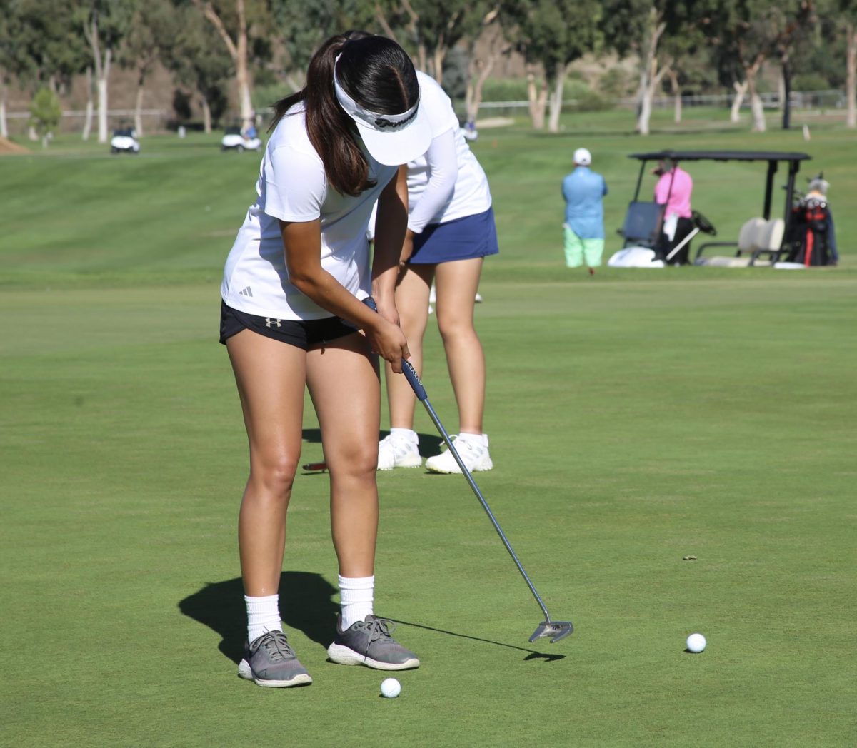 On Sep.18, Bonita Vista High (BVH) varsity girls golf player and sophomore, Andrea Roman putts the golf ball into the hole, helping BVH in their match against Mater Dei High. Head varsity girls golf coach Tony Valdez focuses on the girls short game in training, which helps Roman in this moment.

Provided by Alexis Acosta