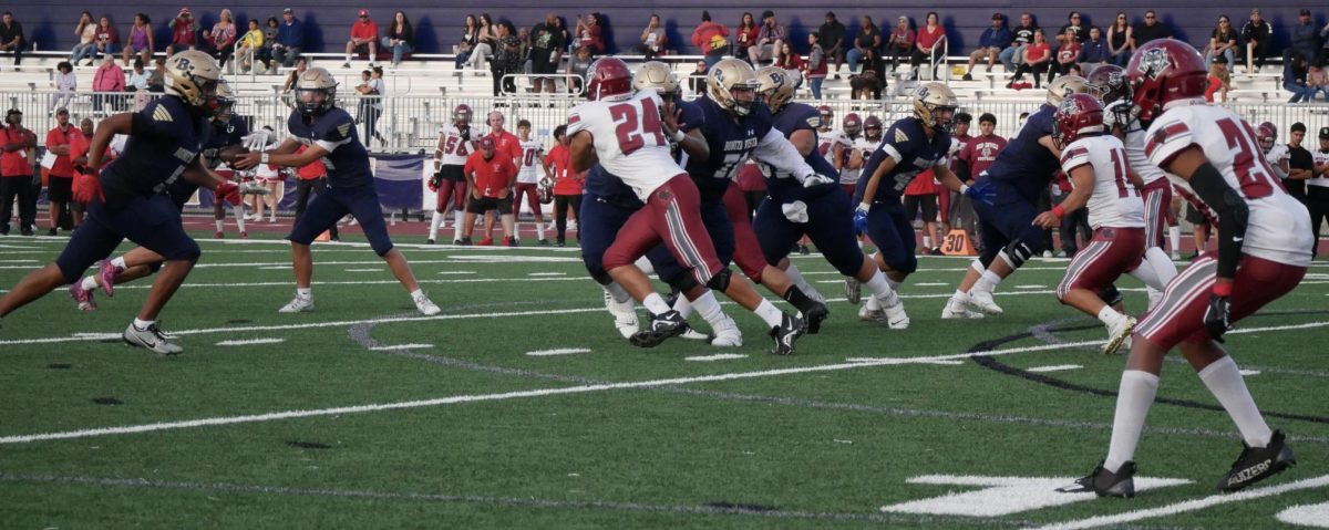 On Sep. 1, 2023, the Bonita Vista High (BVH) boys Varsity Football team faced off against the Sweetwater High School (SHS) Red Devils. BVH quarterback and junior Isayah Luna (4) hands the ball off to running back (RB) and senior Caden Ada-Tanehill (22) behind the protection of the offensive line.