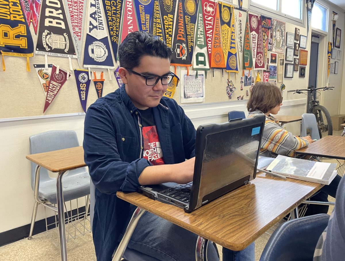 IB diploma candidate and senior Jonathan Enriquez happily focuses on reading the agenda for the day in his IB English HL2 class. Enriquez is a diligent worker in all of his classes and maintains a high grade point average (GPA).