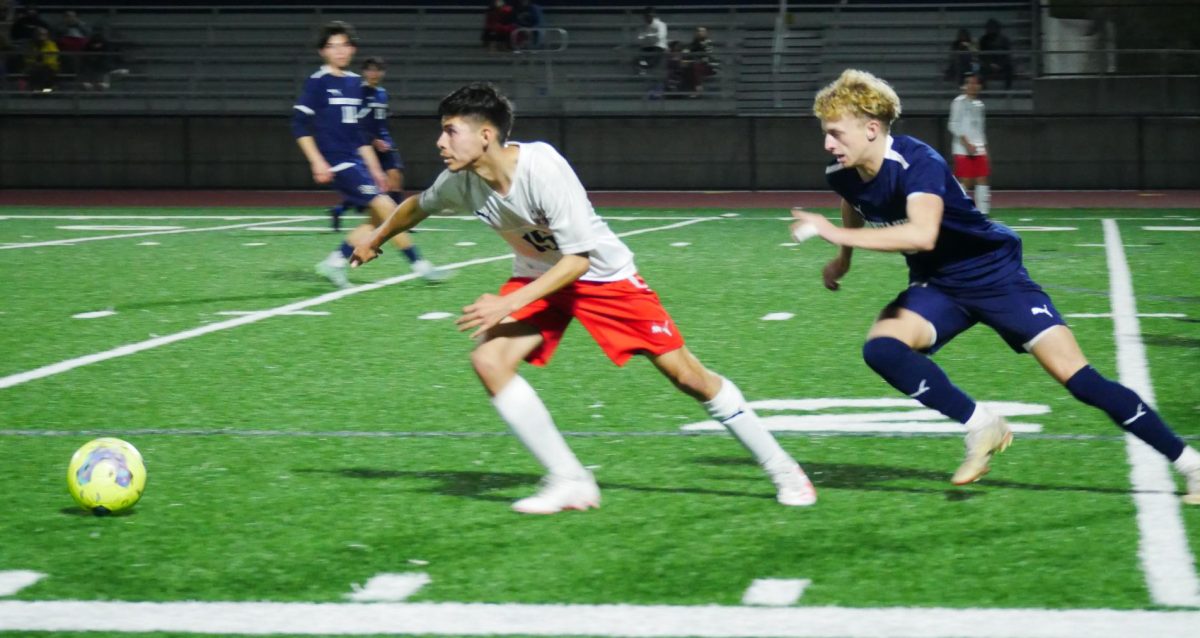 At the Bonita Vista High (BVH) stadium on Jan. 24,  BVH boys soccer ties Montgomery High. Right wing and junior Hayden McMackin (20) catches up to senior Luis Ortiz (15) as they race to gain possession of the ball.