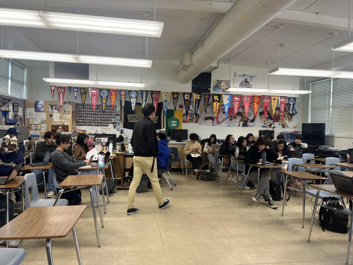 International Baccalaureate (IB) English teacher Raymond Chhan roams around his third period class to assist his students. The students are seen preparing for their upcoming English quiz.