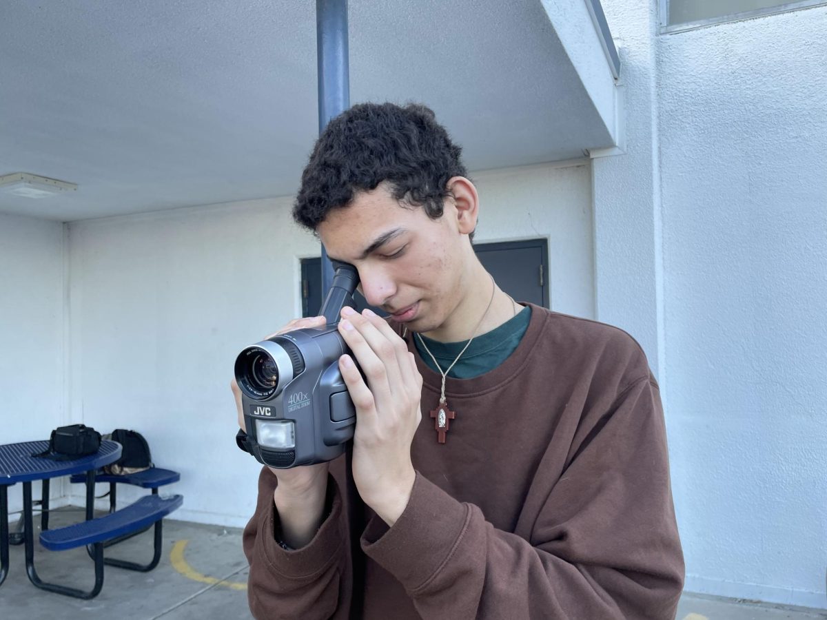 Bonita Vista High (BVH) sophomore Adrian Andrade looks into his digital video tape camcorder in the hopes of recording the local scenery. Andrade is one of many BVH students who have followed the recent trend of buying or finding old cameras and using them to reignite a sense of nostalgia in the form of photos and videos.