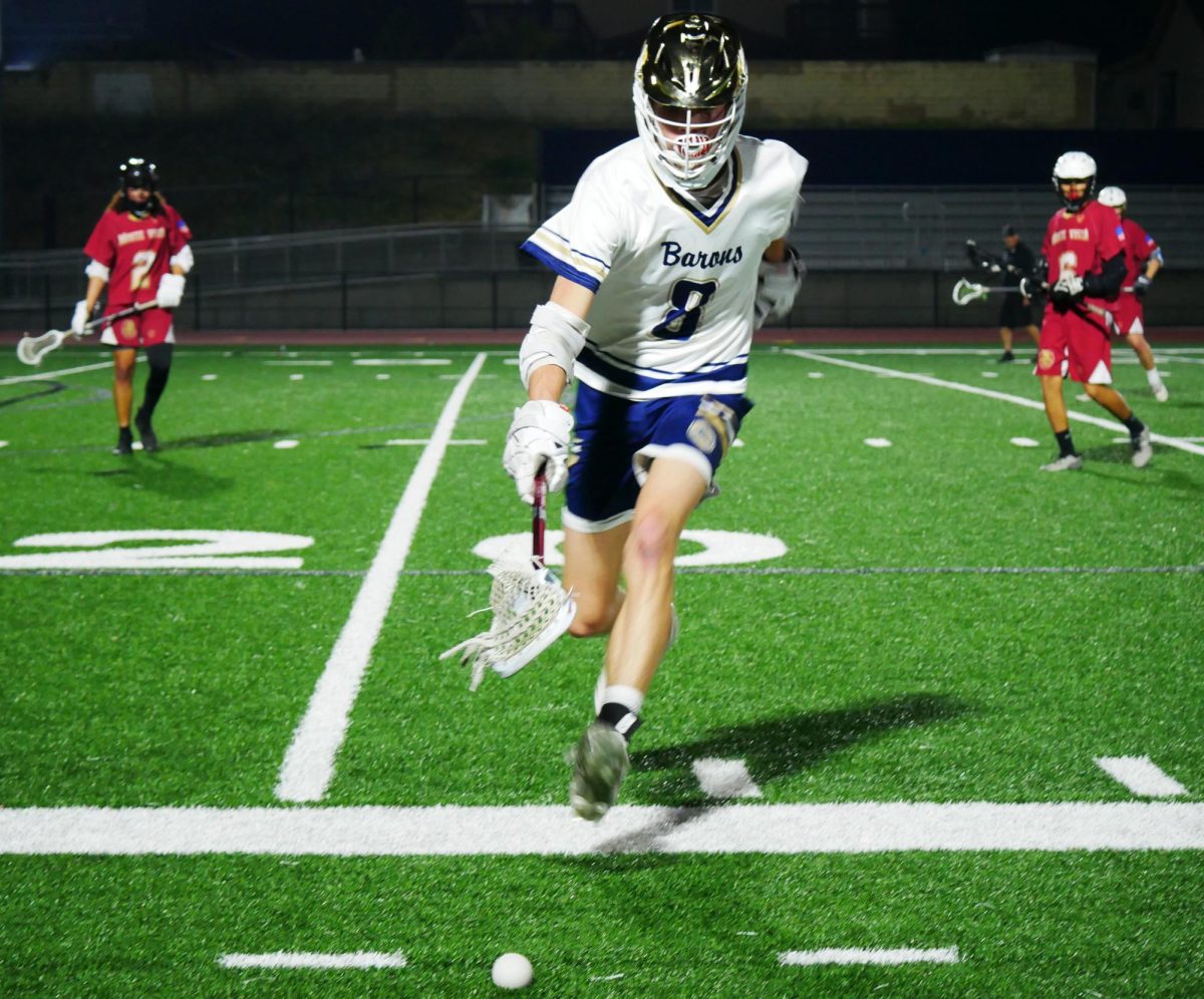 On Feb. 26 at BVHs stadium, BVH boys varsity lacrosse competes against Monte Vista High School (MVHS). Midfielder and senior David Lankard (8) runs to save the ball before it goes out of bounds.