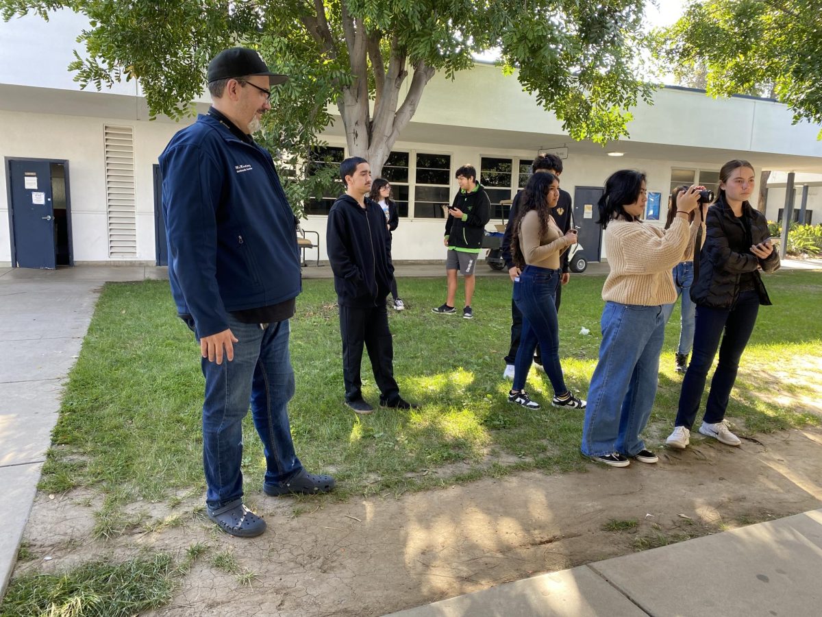 Introduction to Multimedia and Career and Technical Education (CTE) teacher Hugo Martinez, watches his fifth period Introduction to Multimedia class work on their assignment. He stands near the group in case of any questions or advice students need.