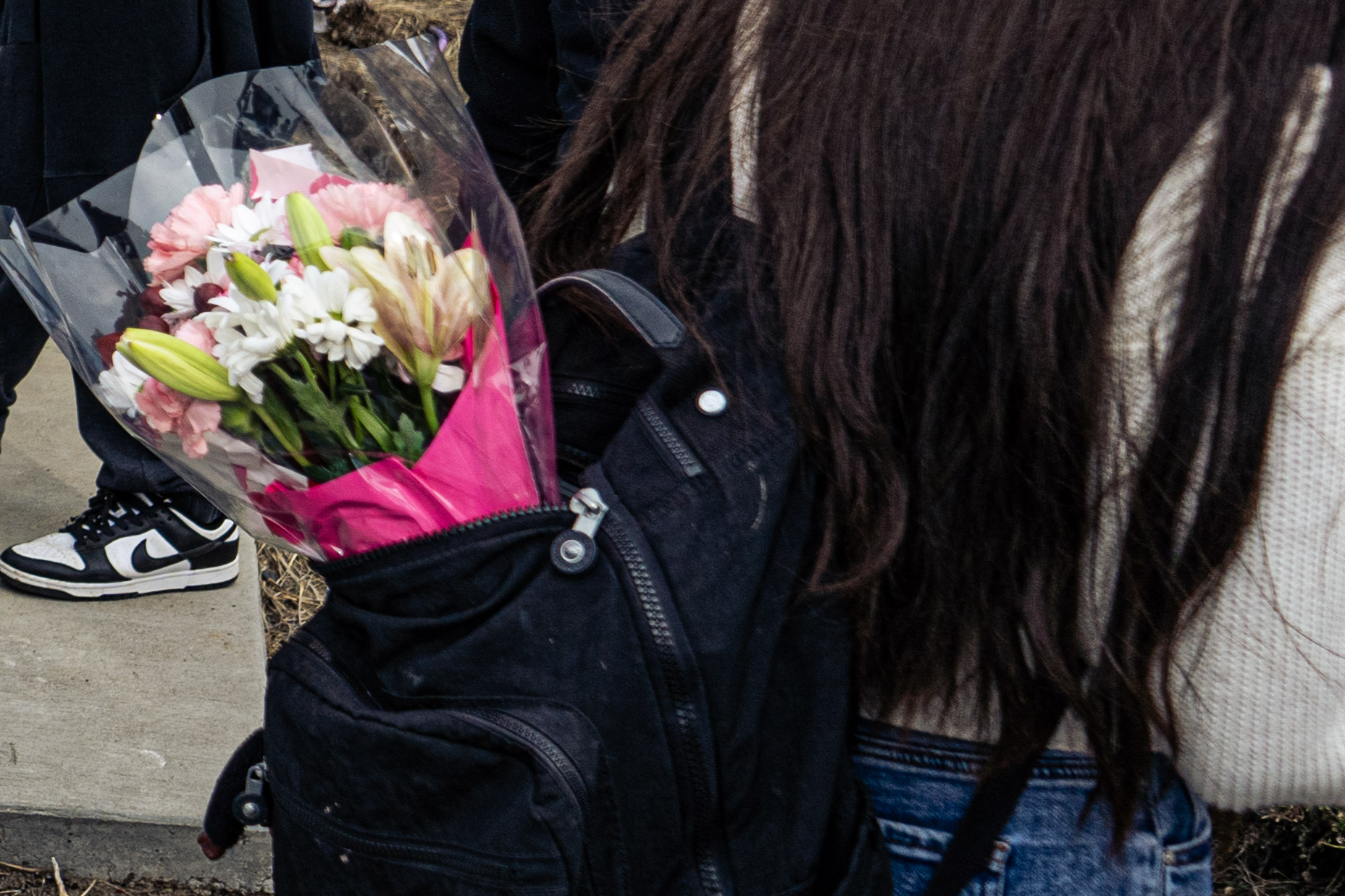 A student is seen with flowers hanging out of their backpack, likely a gift from their significant other. As Valentine's Day approaches, students around campus will likely witness or receive gifts, such as flowers. These practices, along with other factors, continue to define the health of high school relationships.
