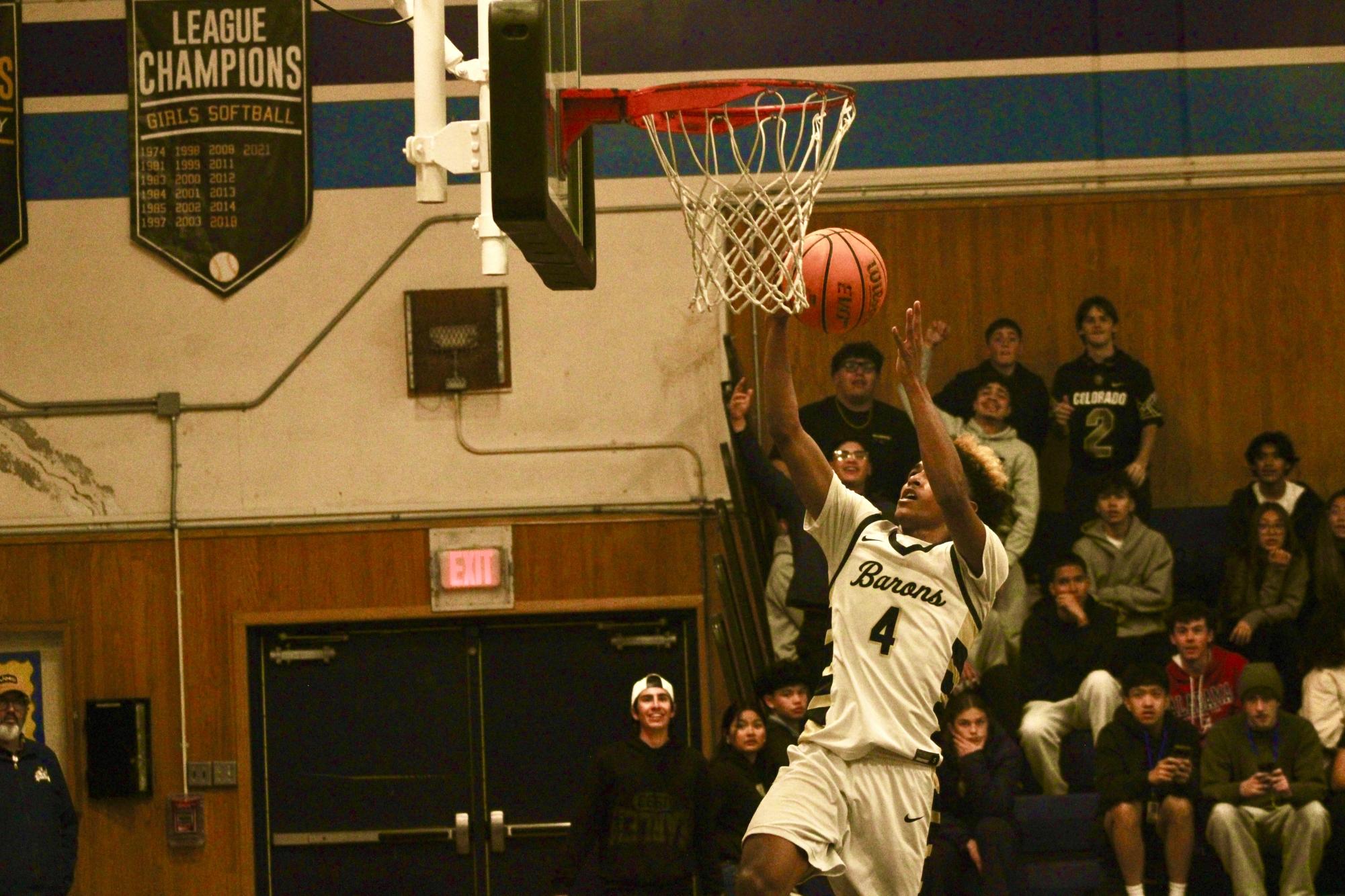 Junior Jerry Stokes completes a layup as he plowed through the defense attempting to block him.